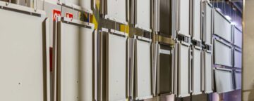 Metalowe panele wiszą na wieszakach w linii produkcyjnej w fabryce.